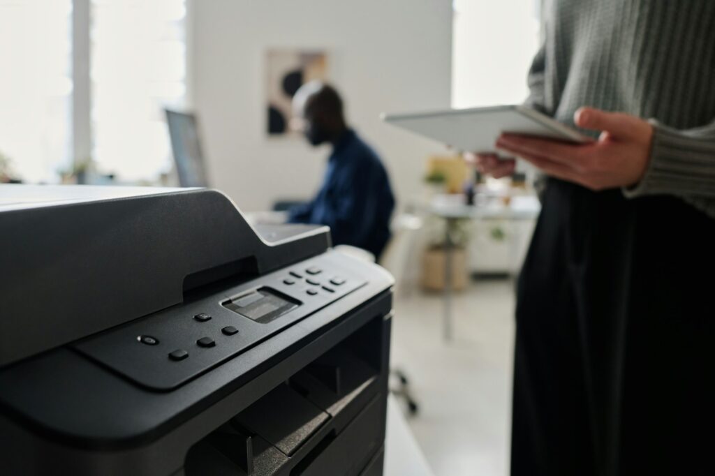 Unrecognizable Woman Using Printer In Office